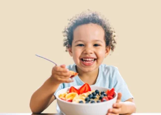 Autonomia alimentar infantil: criança comendo frutas